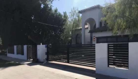 Black aluminum driveway gate installed in Laguna Hills, CA