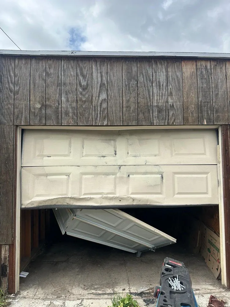 Technician repairing garage door tracks and hardware inside a Laguna Hills garage