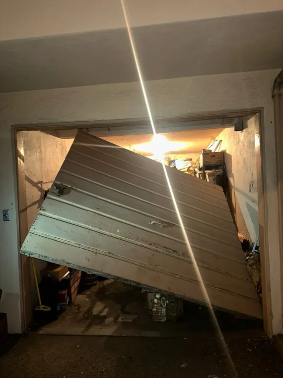 Garage door that came off its tracks before repair in Orange County