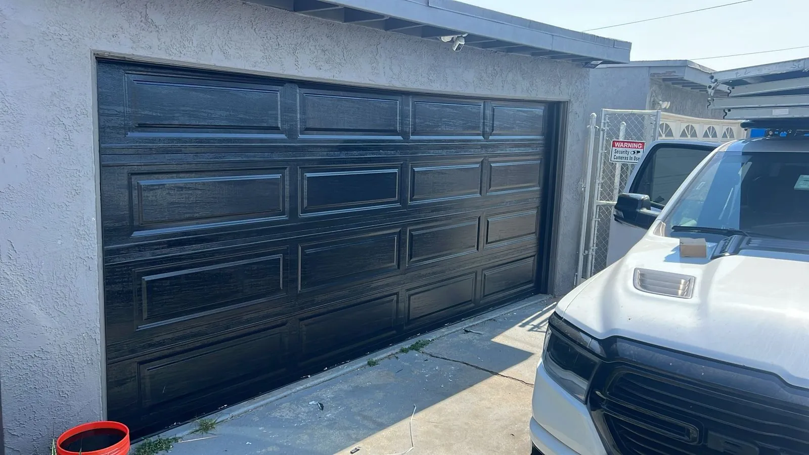 Black double garage door with a pickup parked outside — finished installation project in Orange County, CA