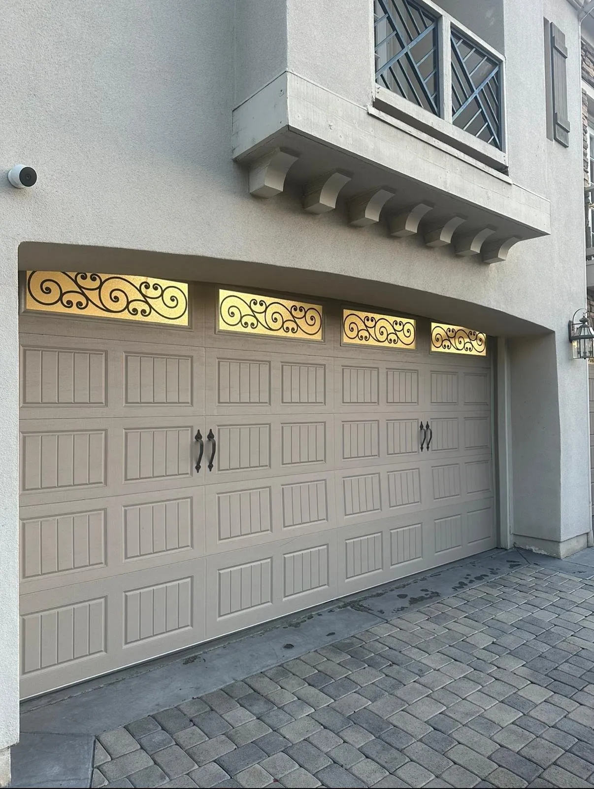 Ornate tan garage door with decorative wrought-iron windows on a Mediterranean-style Orange County home — replacement door styles we install