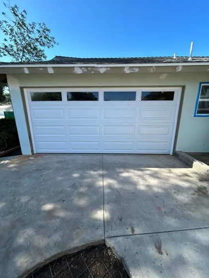 White raised-panel garage door freshly installed on a stucco home — new garage door installation in Orange County, CA