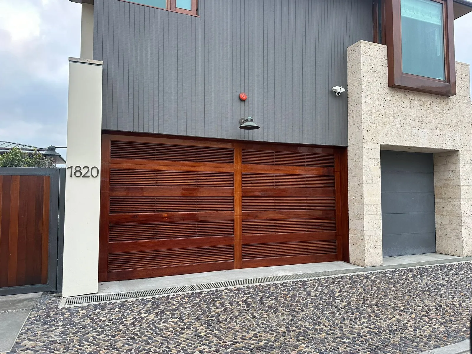 Wood-slat garage door on a gray and stone modern home — HOA-approved door styles in Aliso Viejo and Ladera Ranch