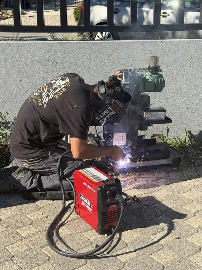 Welder fabricating a custom driveway gate frame — what a professional gate installation includes