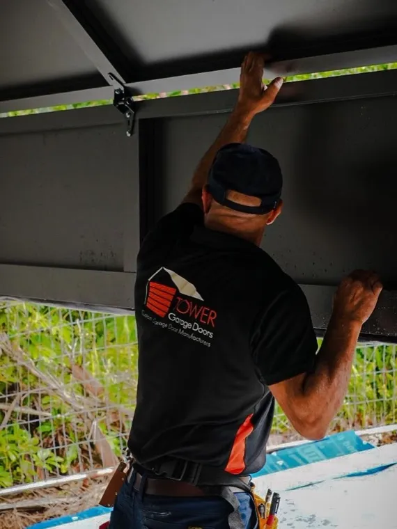 Technician working overhead on a garage door — garage door repair cost guide for Orange County